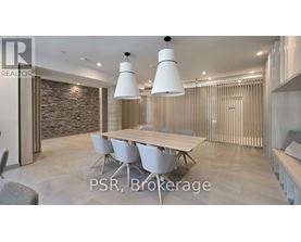 A modern dining room with a stone wall and a long table with chairs.
