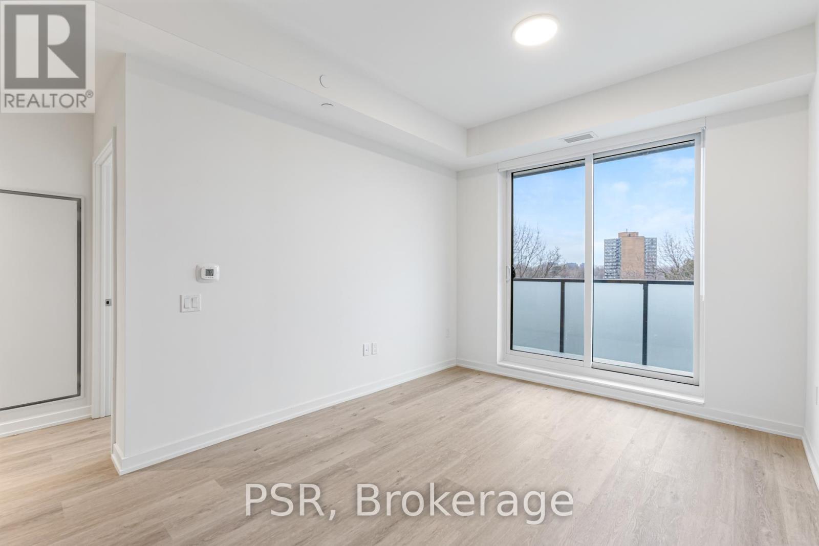 A room with a window showing a view of a building outside.