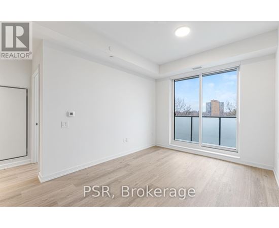 A room with a window showing a view of a building outside.