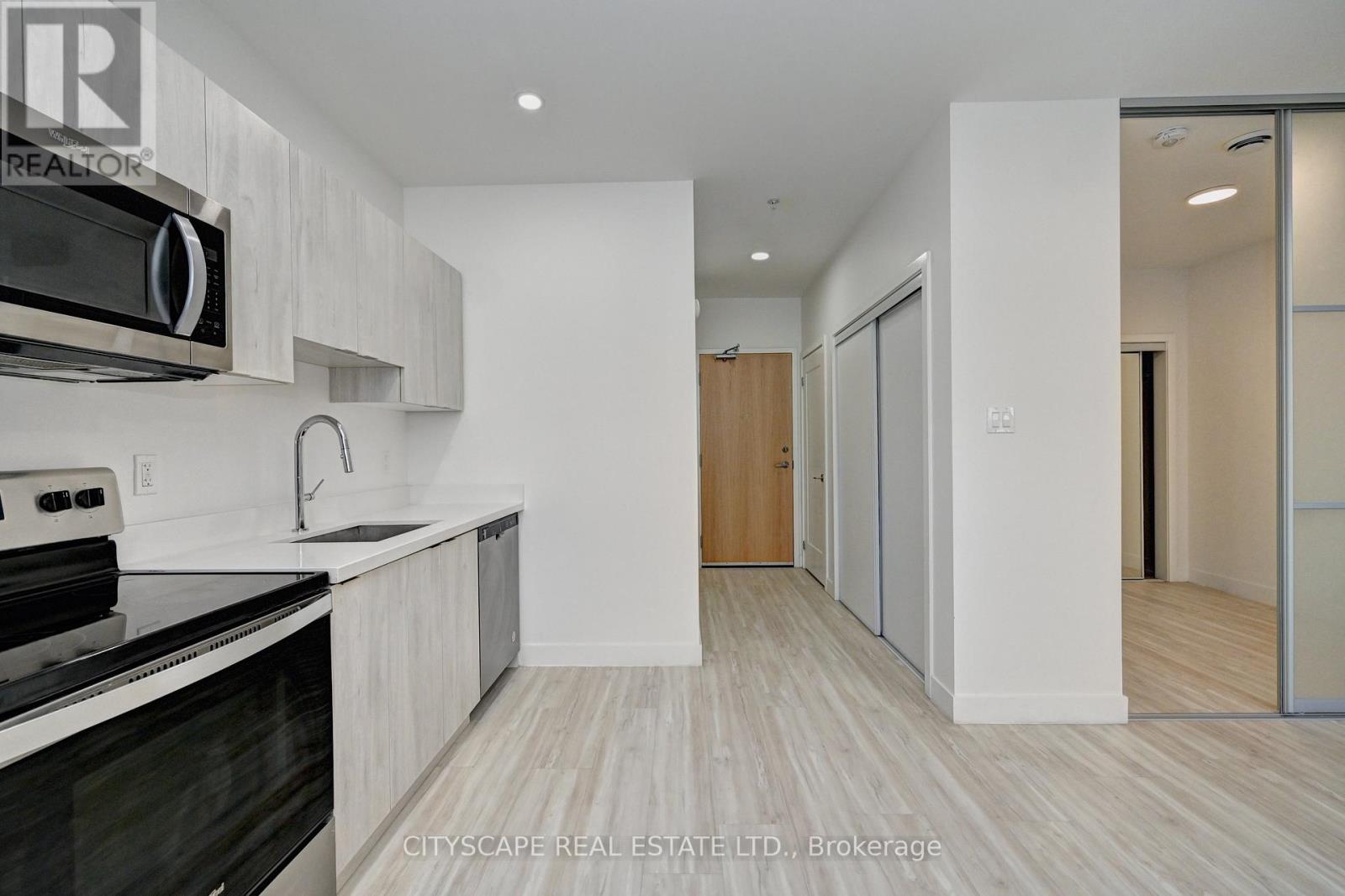 A modern kitchen with a black stove top oven and white cabinets.