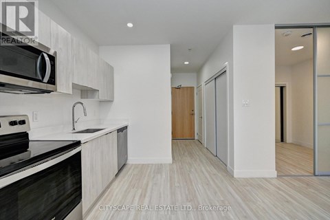 A modern kitchen with a black stove top oven and white cabinets.
