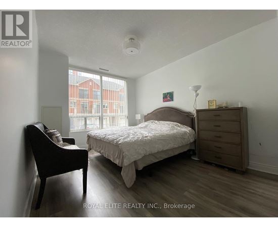 A bedroom with a bed, nightstand, and chair.