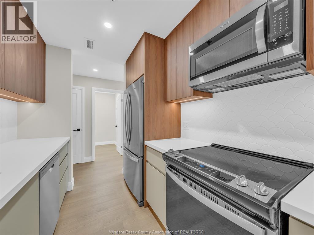 A kitchen with a refrigerator, oven, and microwave.
