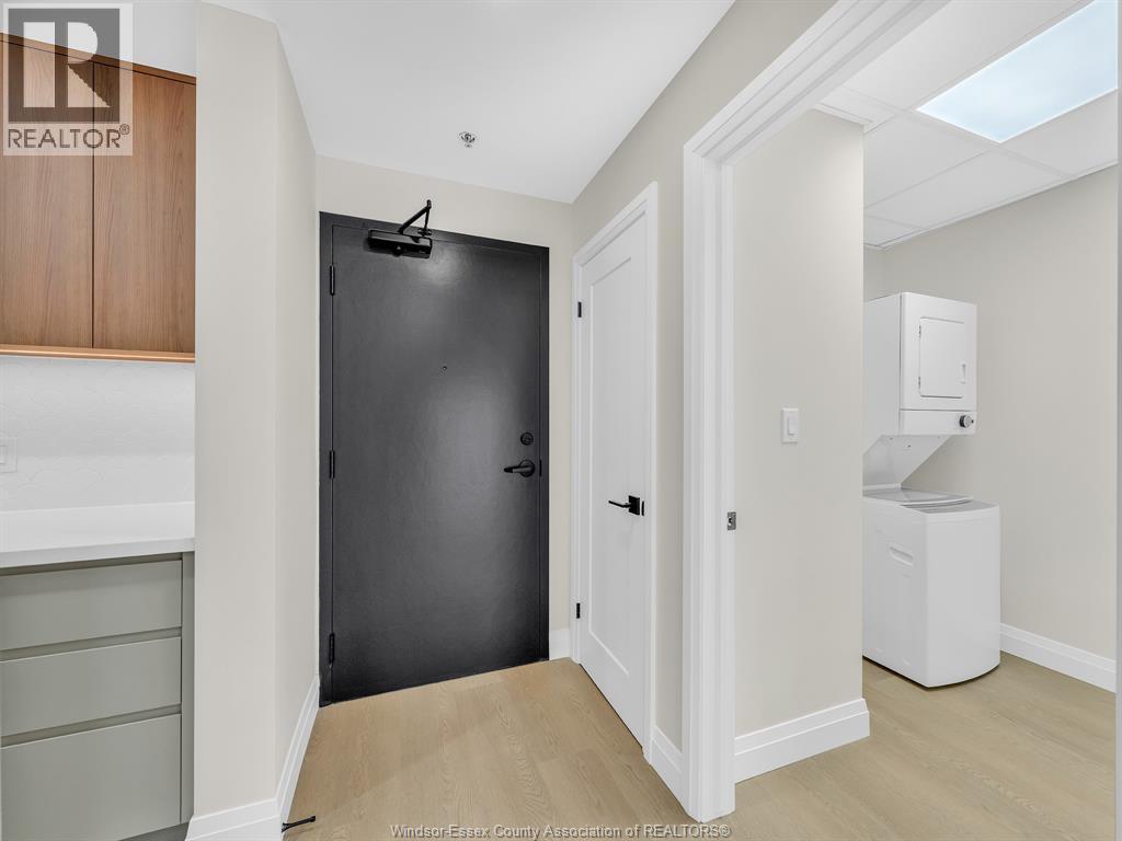 A black door is in a white hallway.
