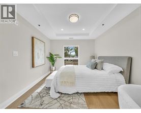 A bedroom with a large bed and a window overlooking trees.
