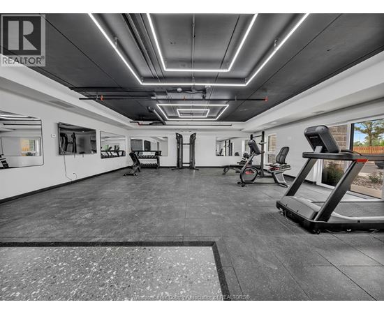 A gym with a variety of equipment including treadmills, weights, and exercise machines.