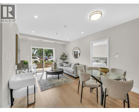 A well-lit, modern dining room with a glass table and chairs.