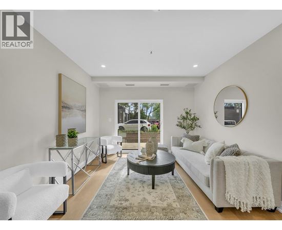 A modern living room with a glass coffee table and a large window.