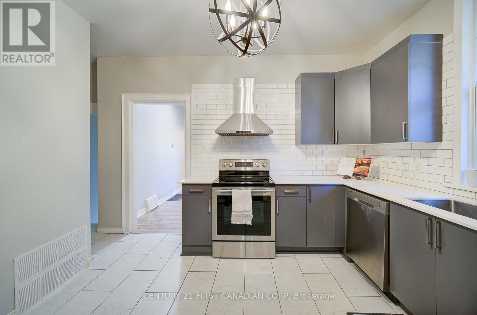 A modern kitchen with stainless steel appliances and a white tiled backsplash.