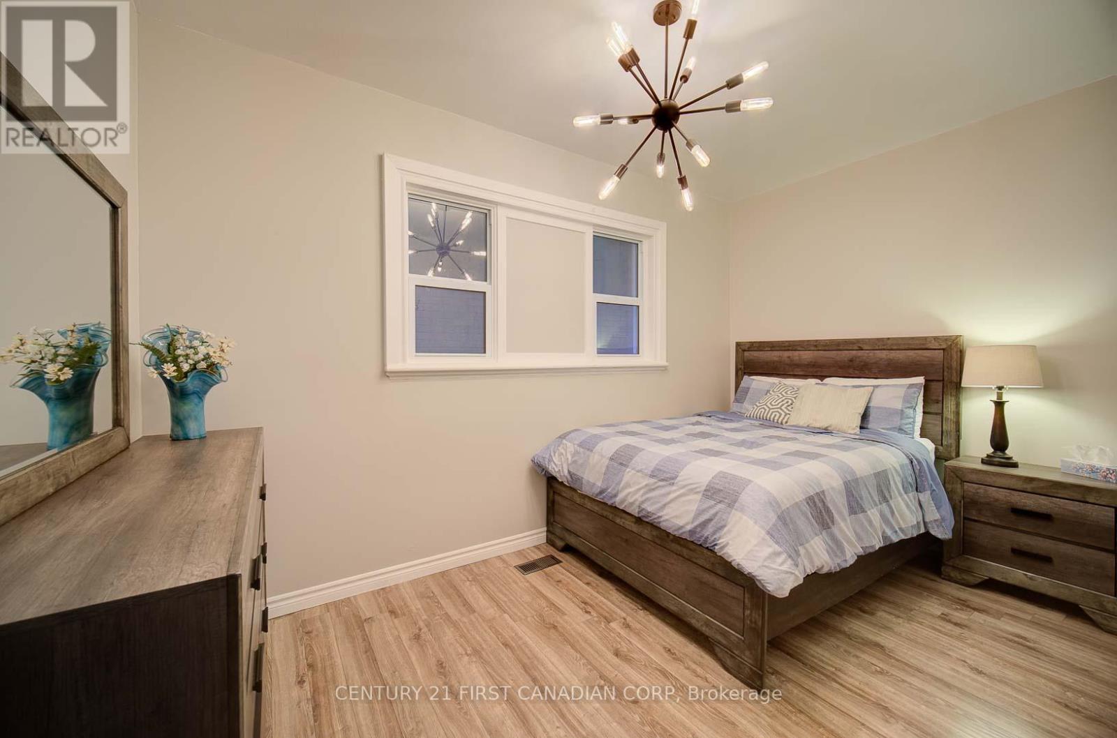 A bedroom with a bed, dresser, and mirror.