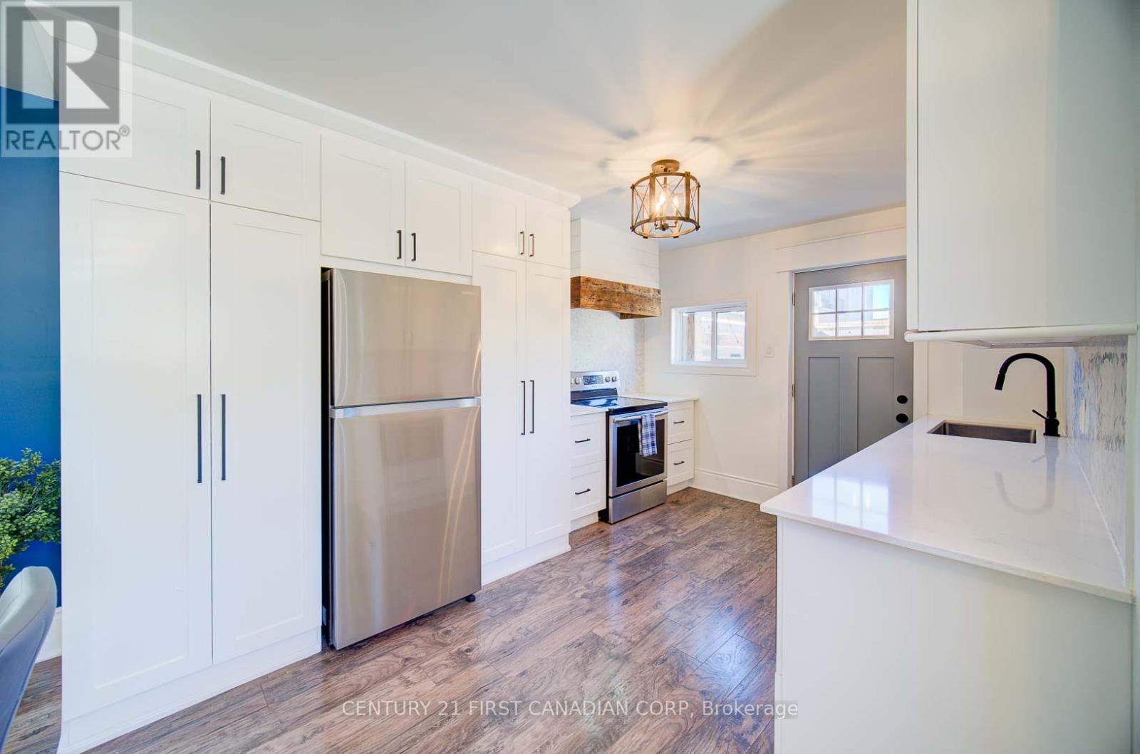 A kitchen with white cabinets and a stainless steel refrigerator.