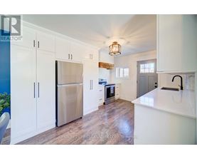 A kitchen with white cabinets and a stainless steel refrigerator.