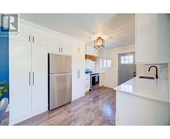 A kitchen with white cabinets and a stainless steel refrigerator.