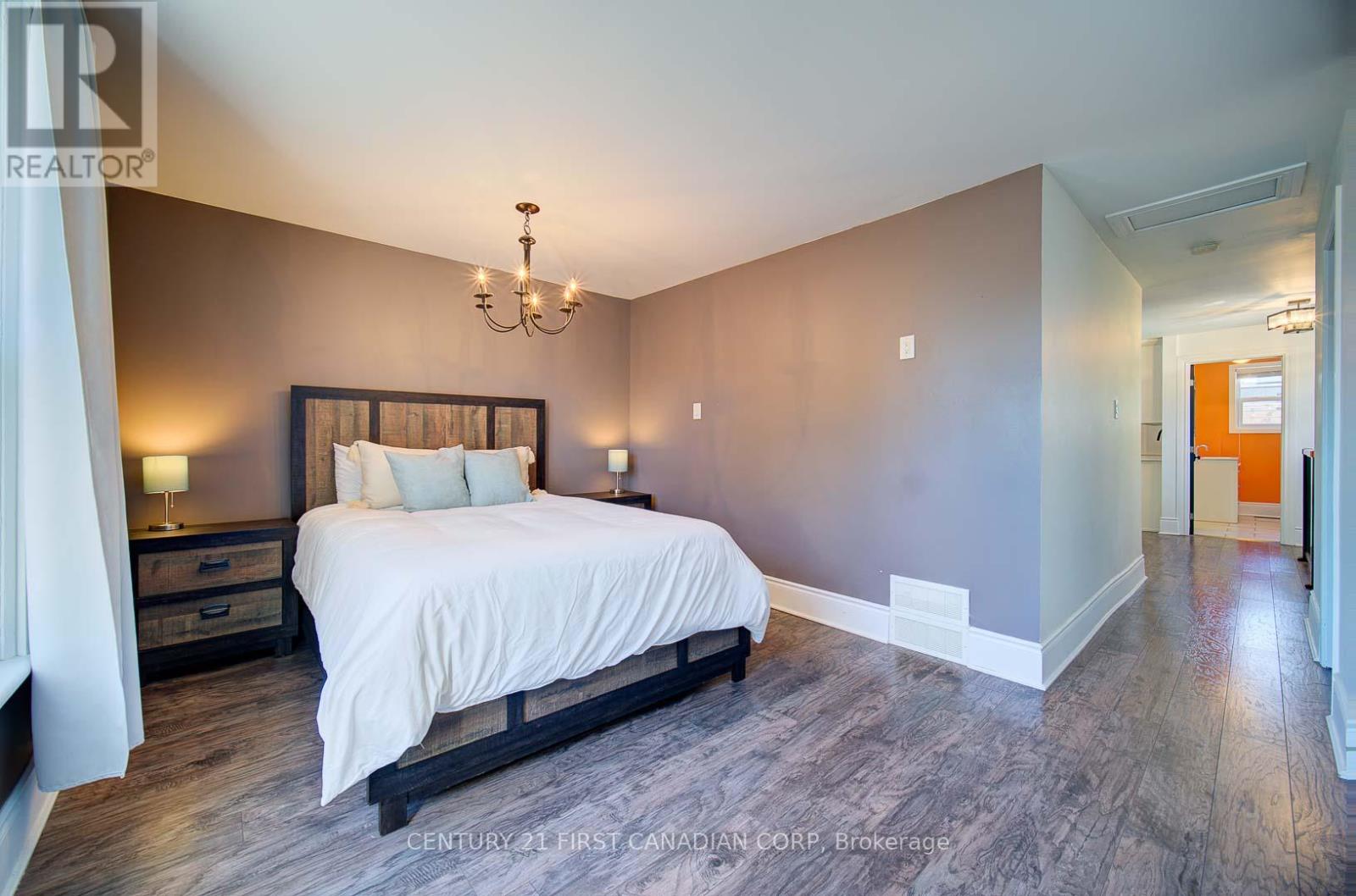 A bedroom with a large bed and a chandelier.