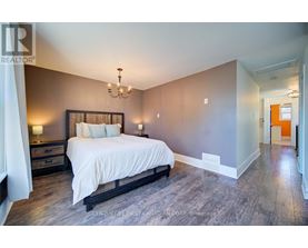 A bedroom with a large bed and a chandelier.