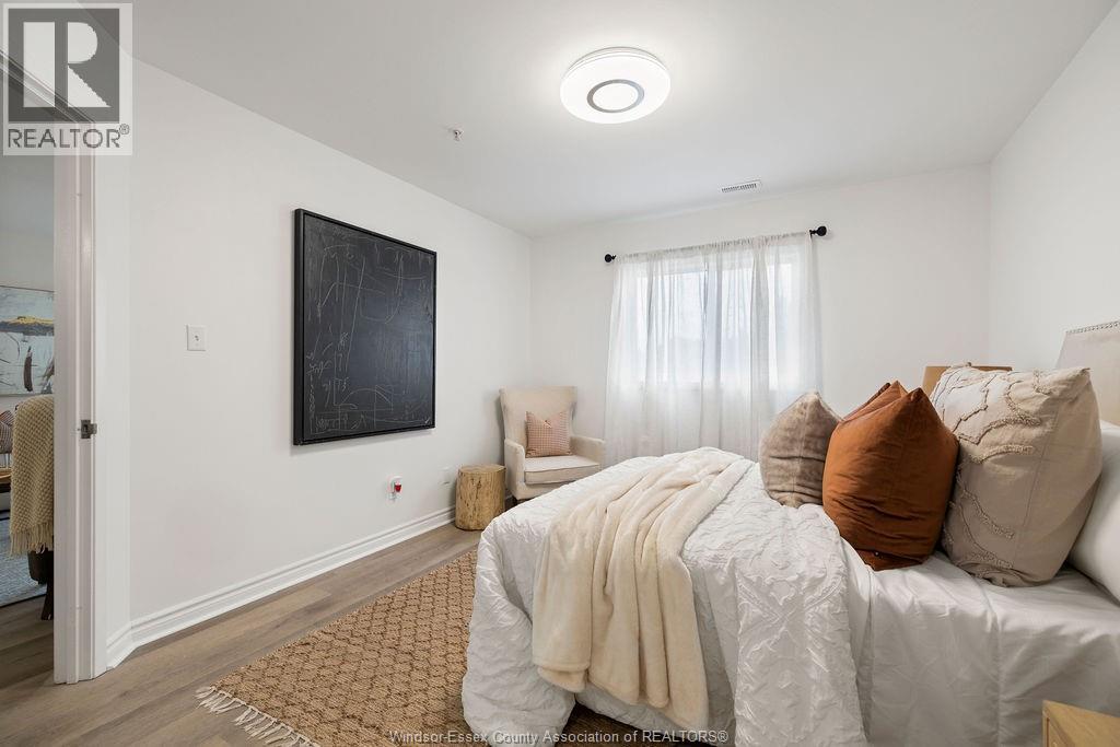 A bedroom with a large bed and a painting on the wall.