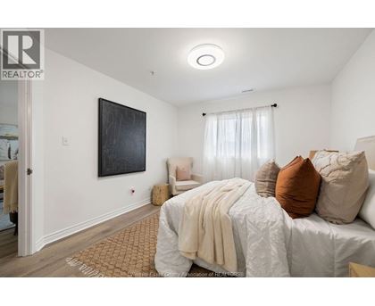 A bedroom with a large bed and a painting on the wall.
