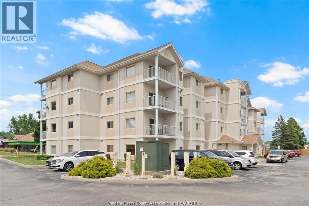 A large apartment complex with a parking lot in front.