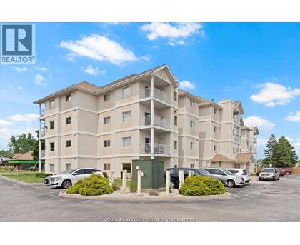 A large apartment complex with a parking lot in front.