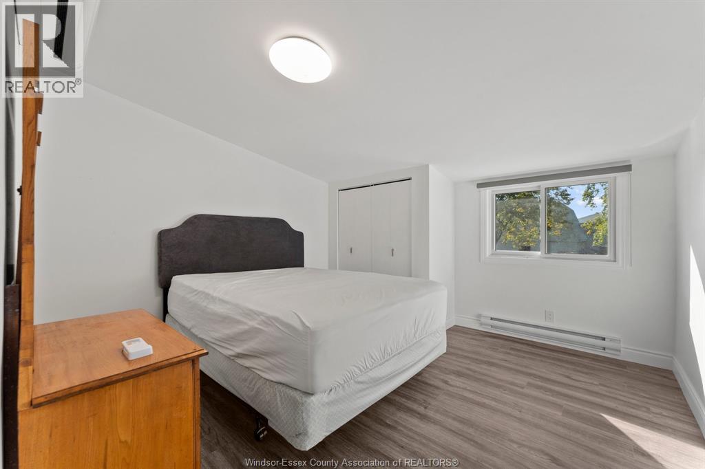 A bedroom with a bed, nightstand, and window.