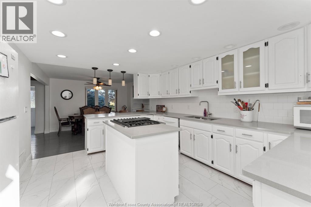 A kitchen with white cabinets and a large island.