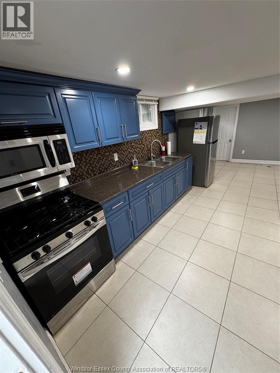 A kitchen with blue cabinets and a black stove top.