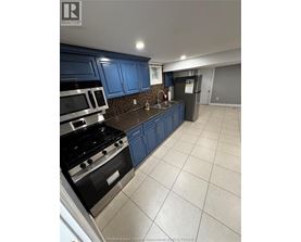 A kitchen with blue cabinets and a black stove top.