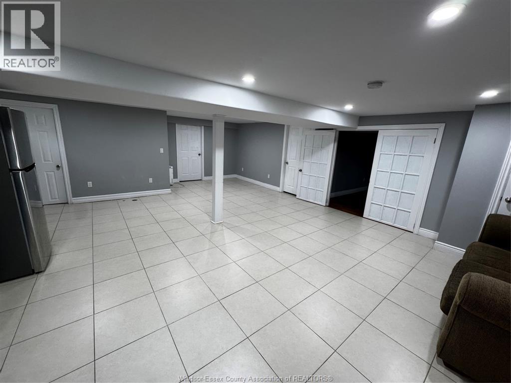 A spacious room with tile flooring and multiple doors.