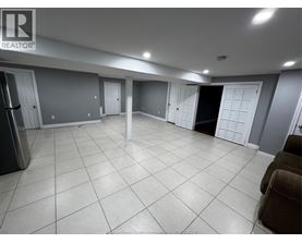 A spacious room with tile flooring and multiple doors.