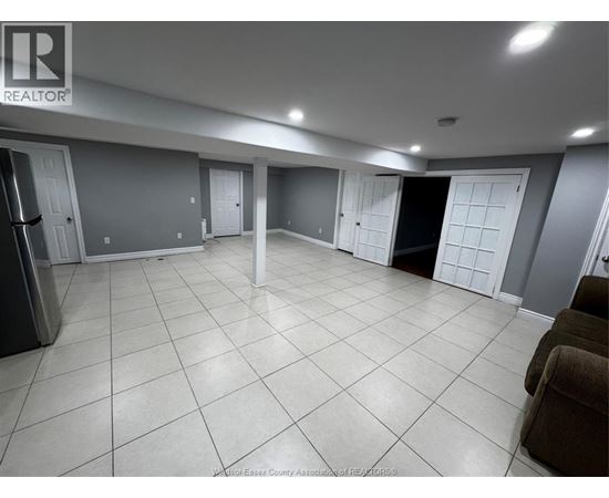 A spacious room with tile flooring and multiple doors.