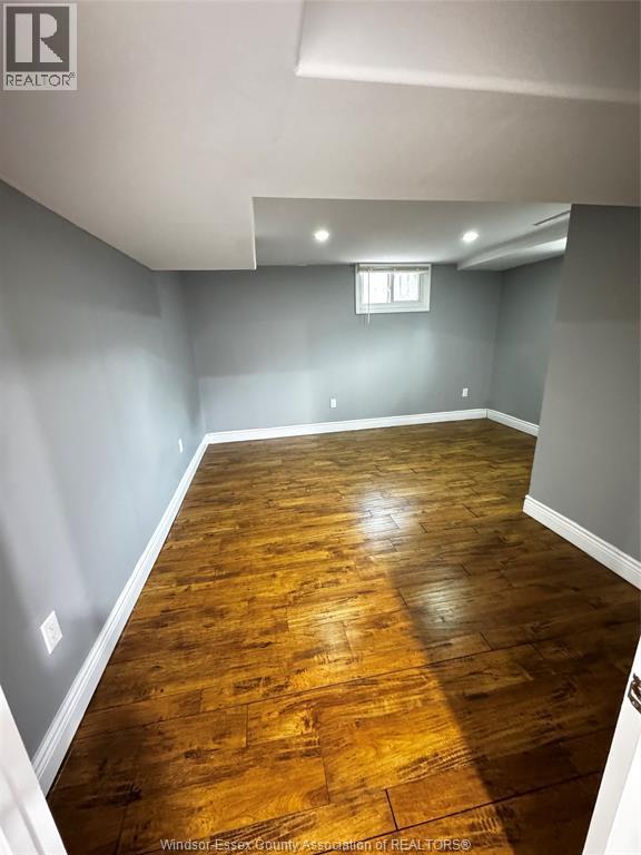 A room with wooden flooring and a window.