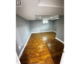 A room with wooden flooring and a window.