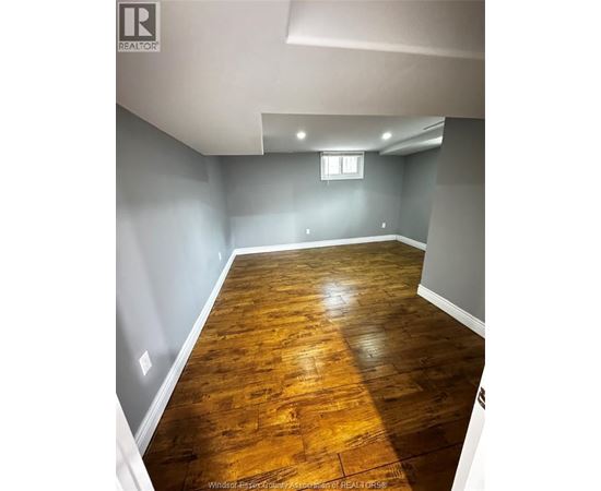 A room with wooden flooring and a window.