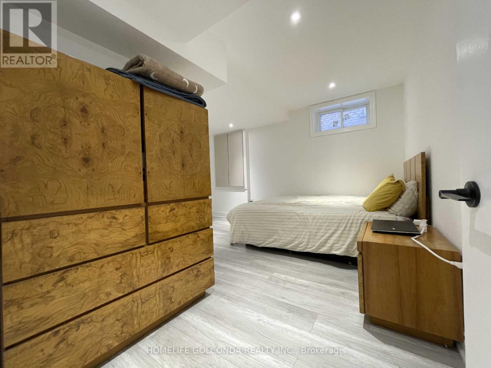 A bedroom with a large bed and a wooden wardrobe.