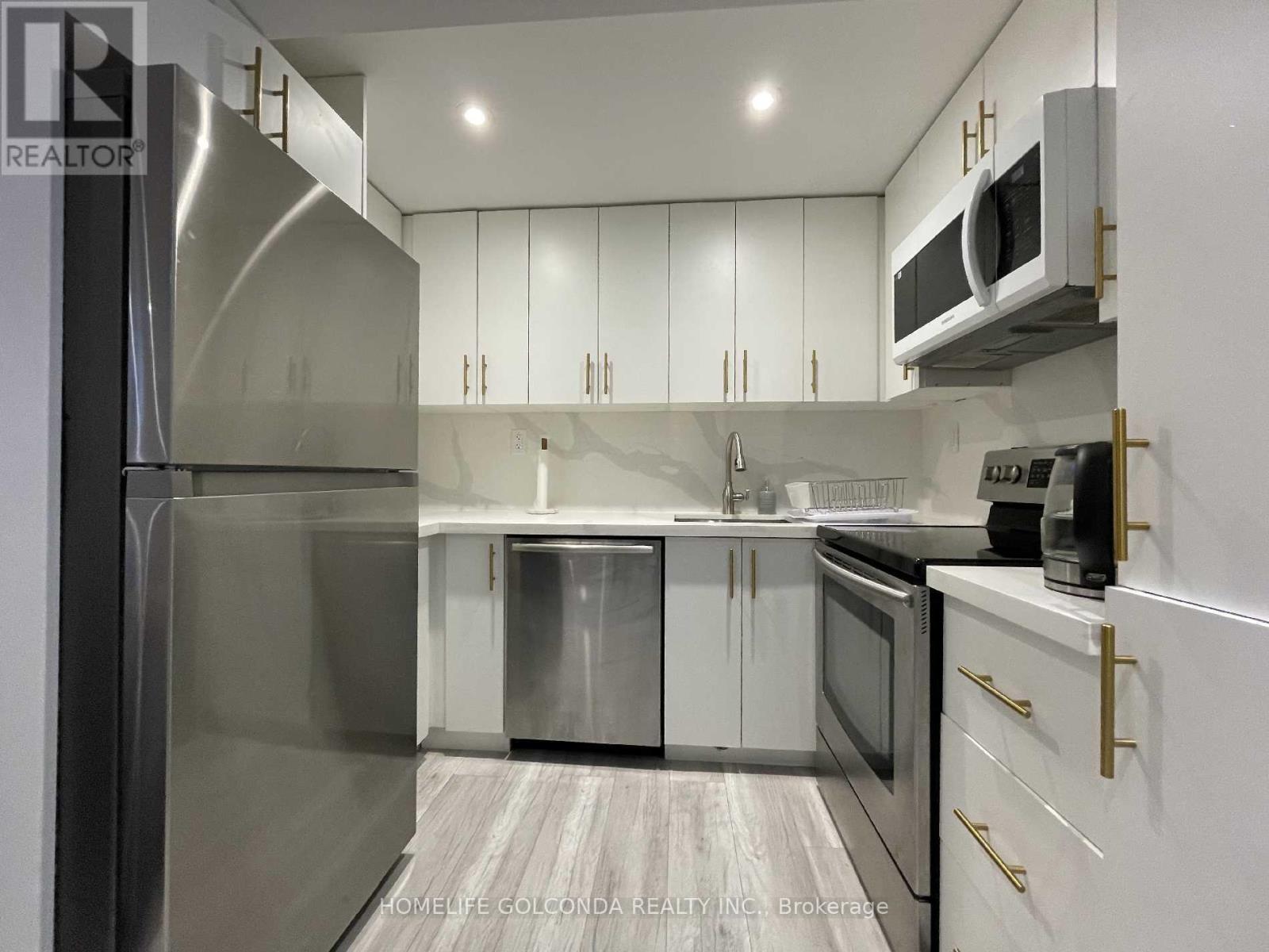 A modern kitchen with white cabinets and stainless steel appliances.