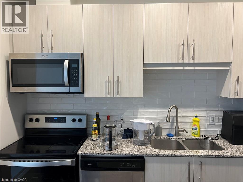 A kitchen with a microwave, oven, sink and dishwasher.