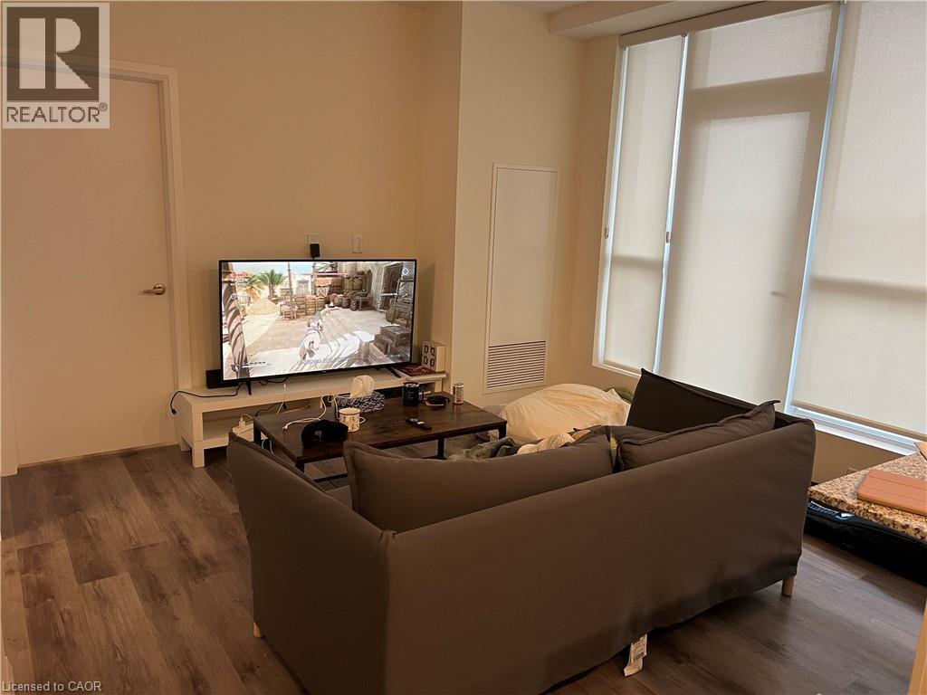 A living room with a large couch and a television on a stand.