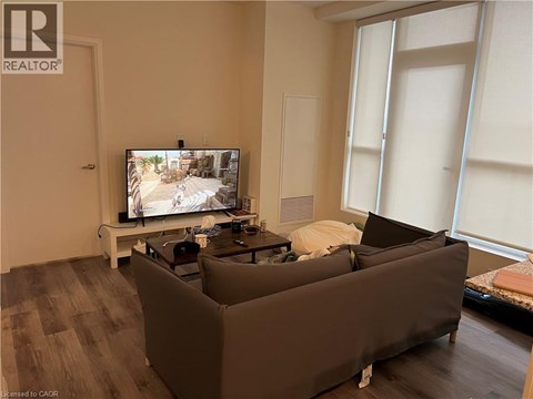 A living room with a large couch and a television on a stand.