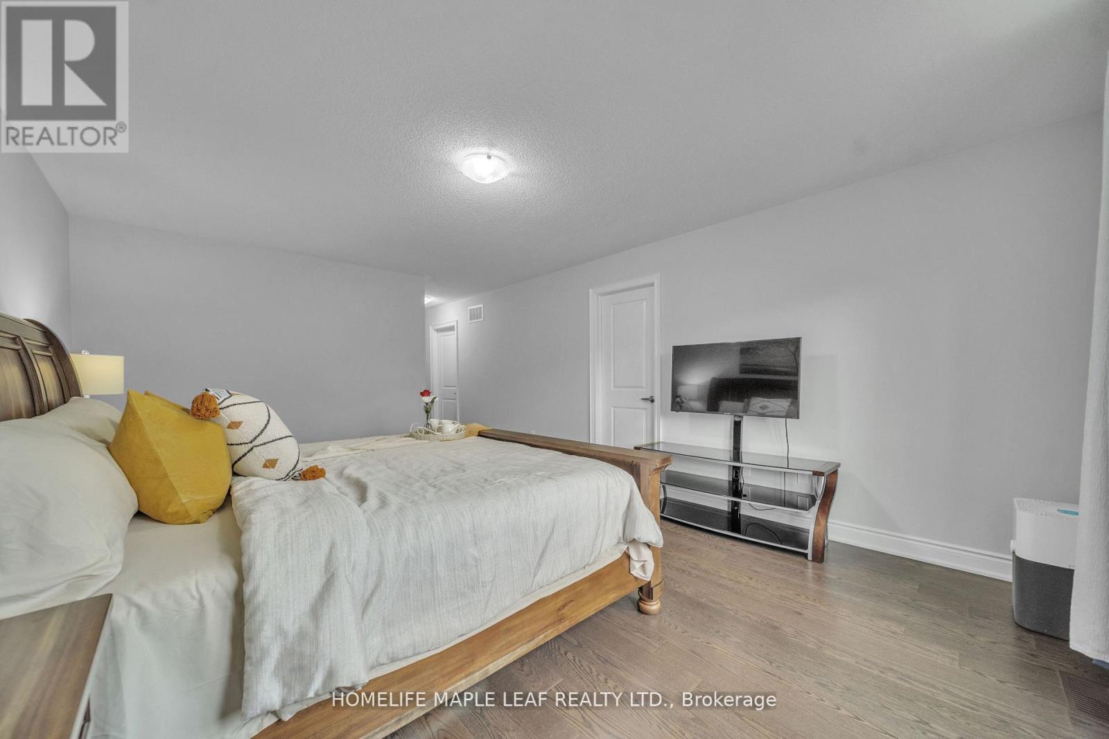 A bedroom with a bed, a nightstand, and a TV.
