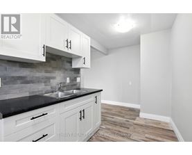 A kitchen with white cabinets and a black counter top.