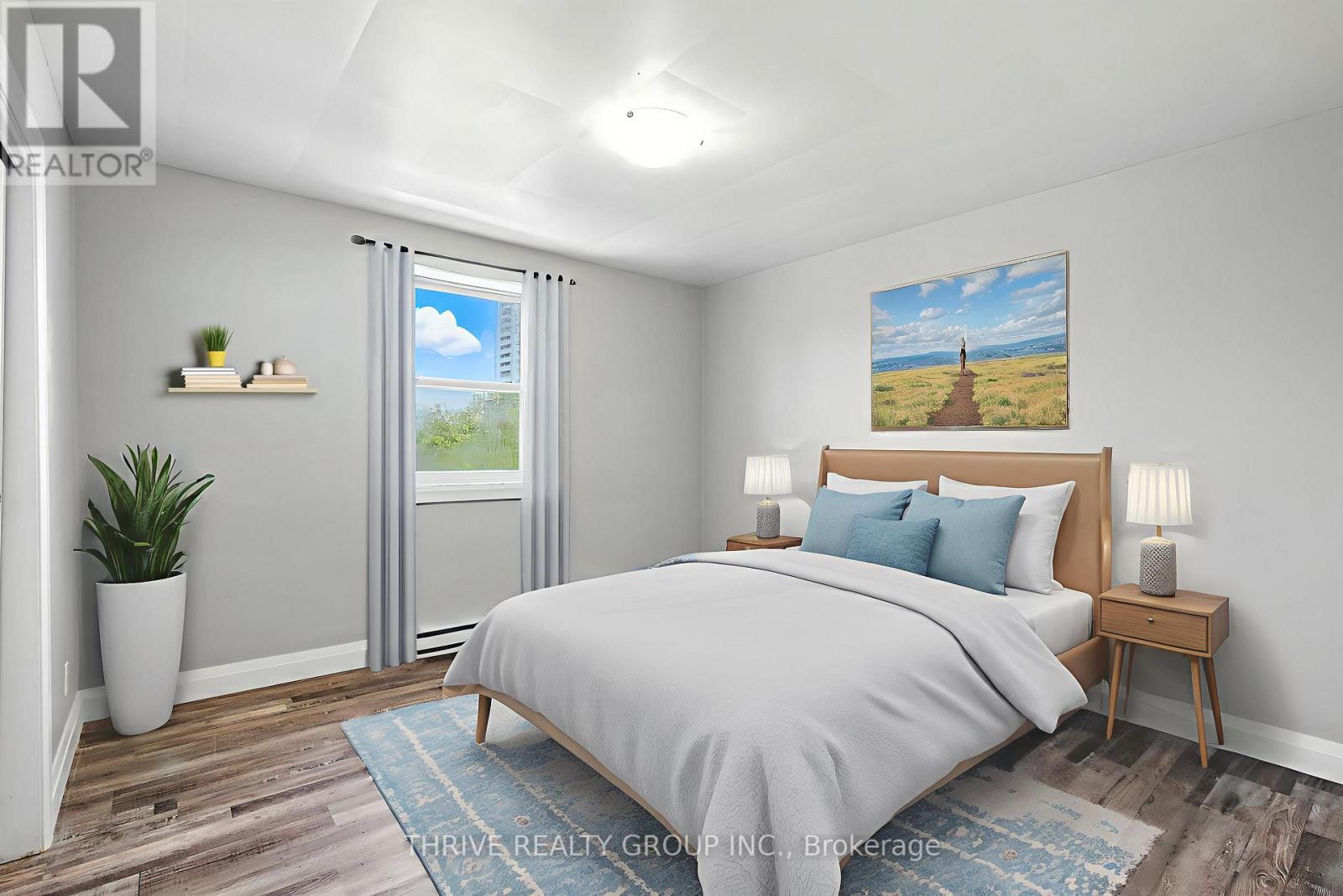 A bedroom with a large bed, a potted plant, and a painting on the wall.