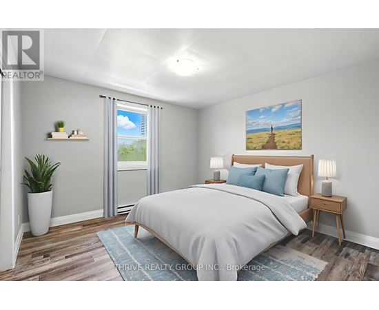 A bedroom with a large bed, a potted plant, and a painting on the wall.