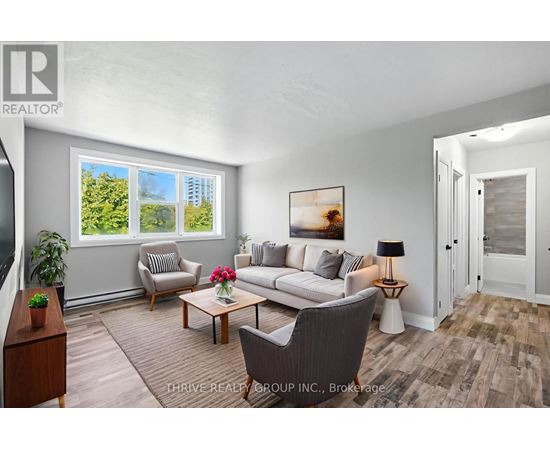 A living room with a couch, chair, and a table with a lamp on it.