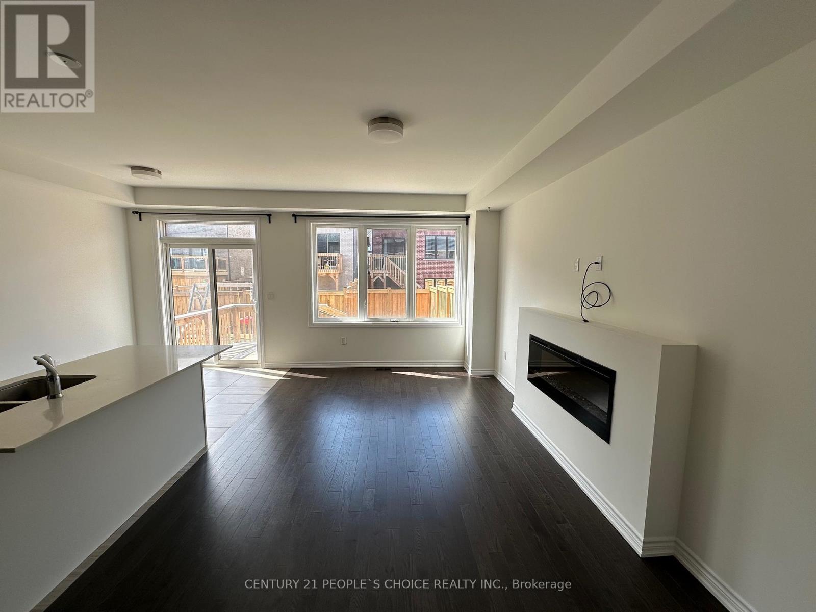 A spacious living room with a fireplace and large windows.