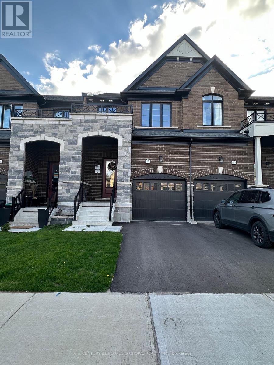 A large house with a stone archway entrance and a car parked in the driveway.