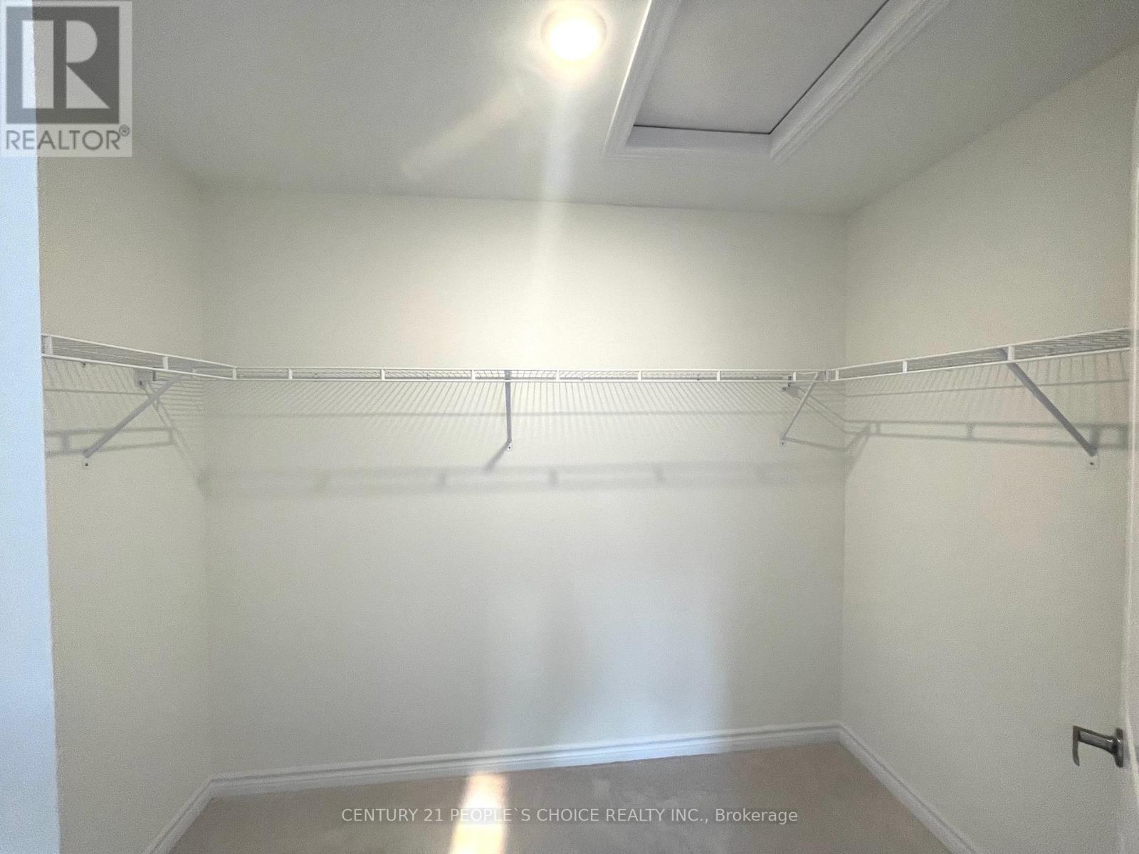 A white bedroom with a bed on the left and a closet on the right.