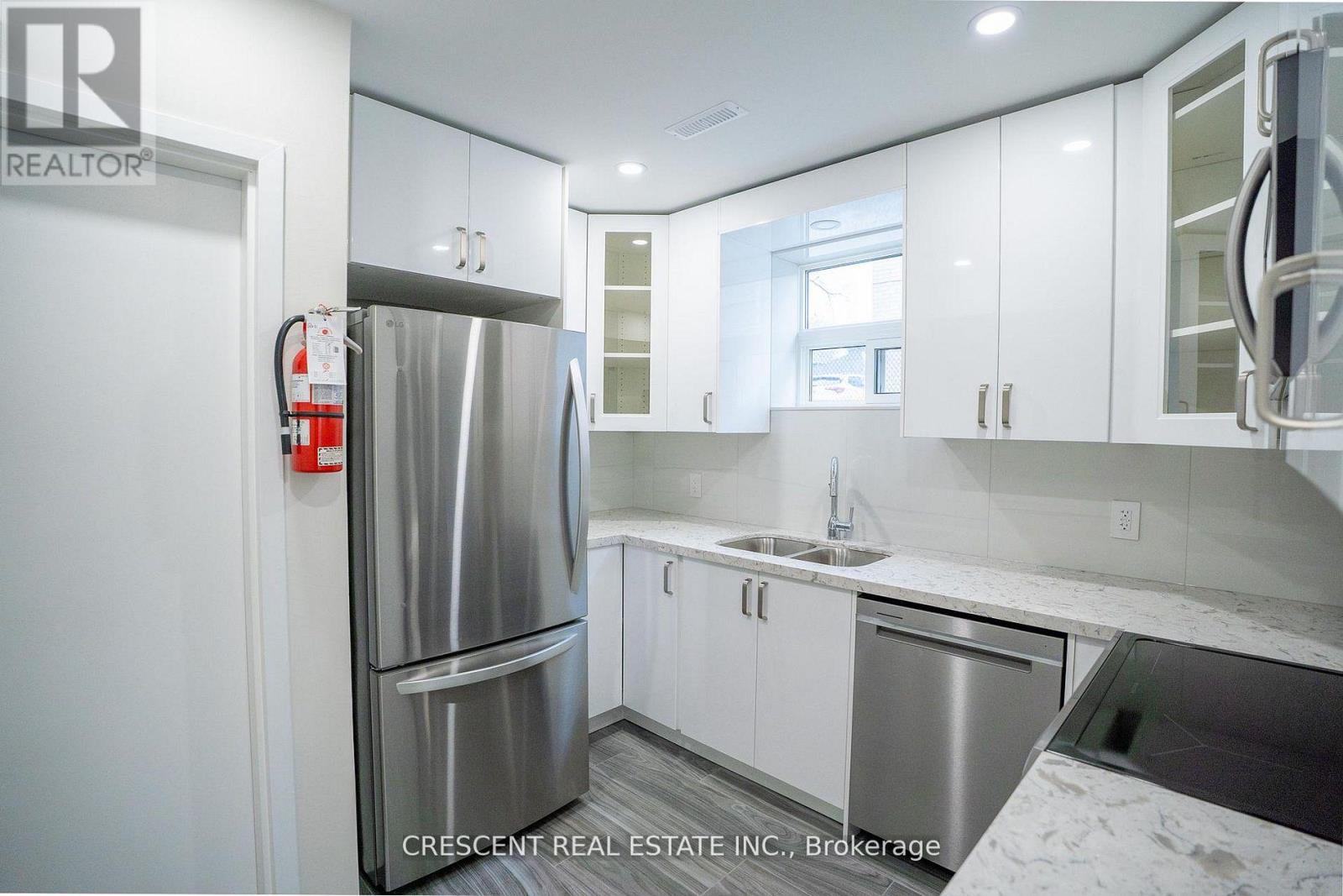 A kitchen with white cabinets and a stainless steel refrigerator.