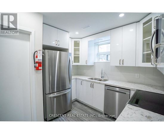 A kitchen with white cabinets and a stainless steel refrigerator.