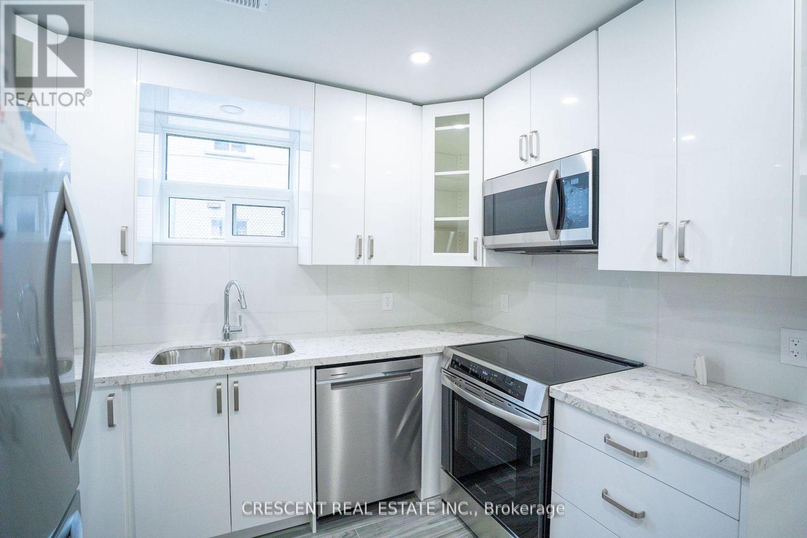 A kitchen with white cabinets and a black stove top oven.