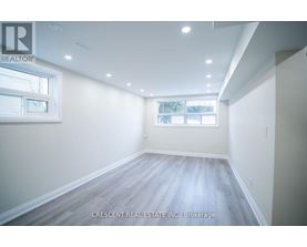 A spacious room with a window and wooden flooring.